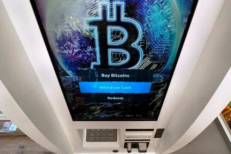 Логотип Биткойн появляется на экране банкомата с криптовалютой в магазине Smokers Choice